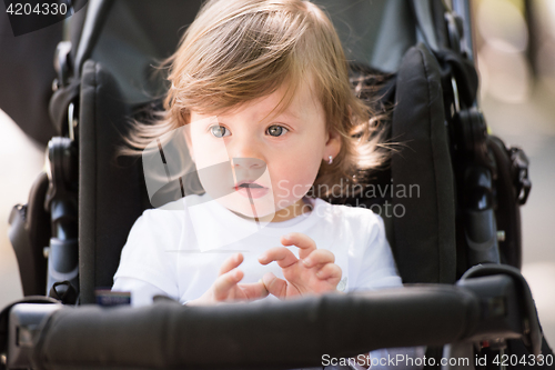 Image of baby girl sitting in the pram