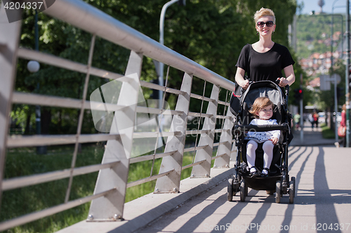 Image of mother pushed her baby daughter in a stroller