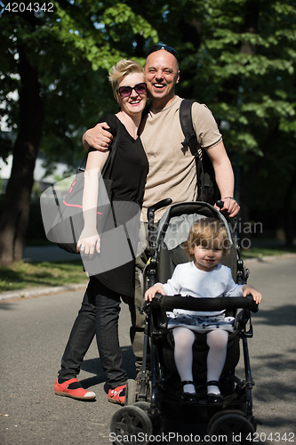 Image of couple with baby pram in summer park