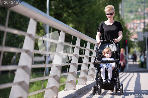 Image of mother pushed her baby daughter in a stroller