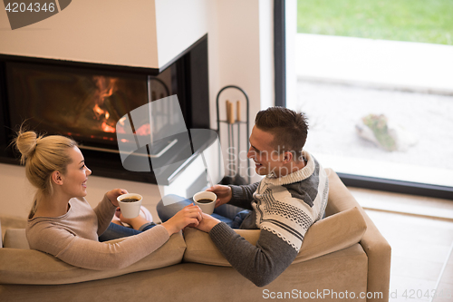 Image of Young couple  in front of fireplace