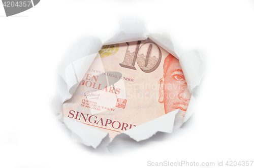 Image of Singapore currency peeking through white paper