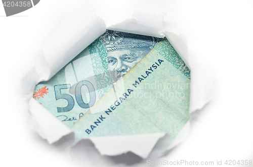 Image of Malaysia currency peeking through white paper