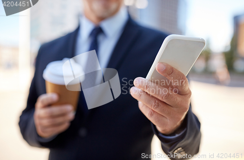 Image of senior businessman with smartphone and coffee