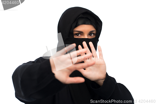Image of muslim woman in hijab showing stop sign