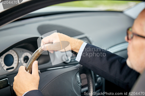 Image of senior businessman hands driving car