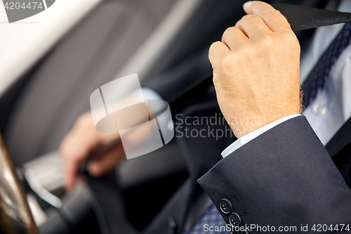 Image of senior businessman fastening car seat belt