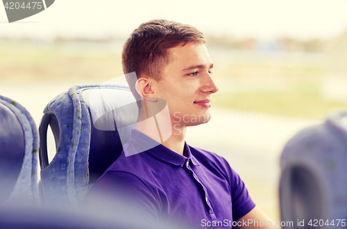 Image of happy young man sitting in travel bus or train