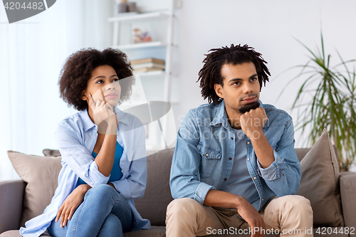 Image of happy couple sitting on sofa at home