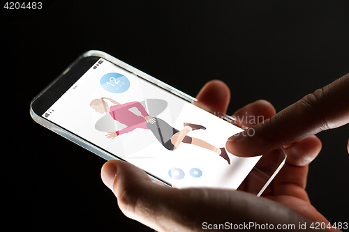 Image of close up of hands with fitness app on smartphone