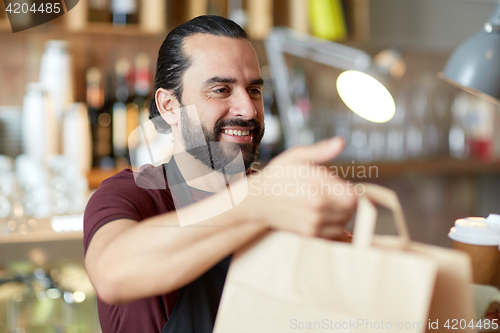 Image of man or waiter with coffee and paper bag at bar