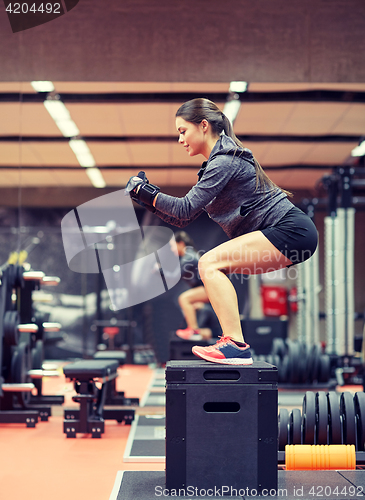 Image of woman doing squats on pnatfom in gym