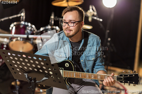 Image of man playing guitar at studio rehearsal