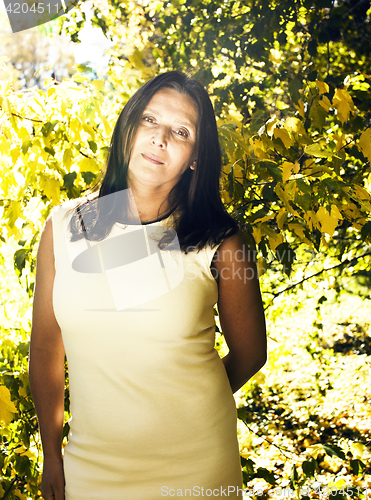 Image of mature real brunette woman in green spring park, lifestyle conce