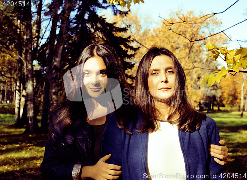 Image of mature real mother with daughter outside autumn fall in park