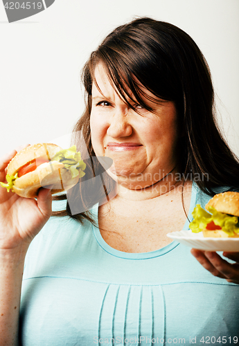 Image of fat white woman having choice between hamburger and salad close 