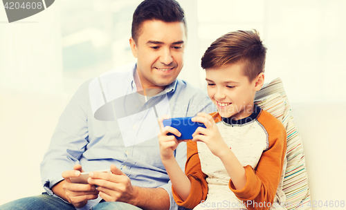 Image of happy father and son with smartphone at home