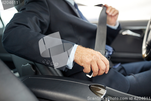 Image of senior businessman fastening car seat belt