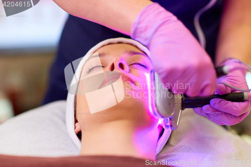 Image of young woman having face microdermabrasion at spa