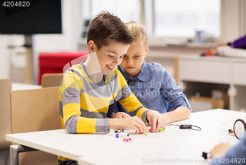 Image of happy children building robots at robotics school