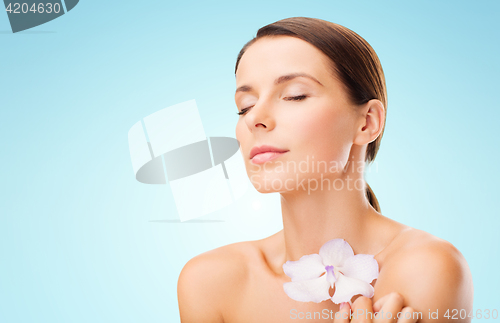 Image of beautiful young woman with orchid flower