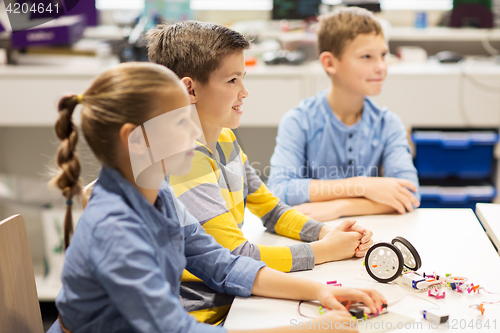 Image of happy children building robots at robotics school