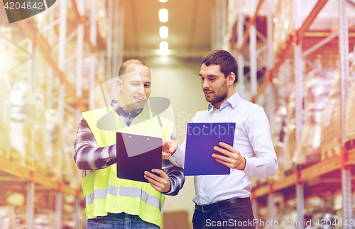 Image of worker and businessmen with clipboard at warehouse