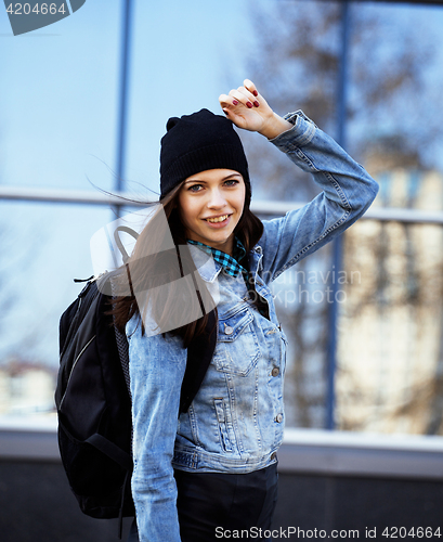 Image of young pretty girl near business building walking