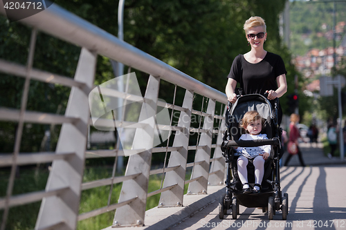 Image of mother pushed her baby daughter in a stroller