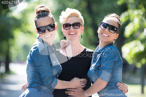 Image of portrait of three young beautiful woman with sunglasses