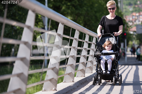 Image of mother pushed her baby daughter in a stroller