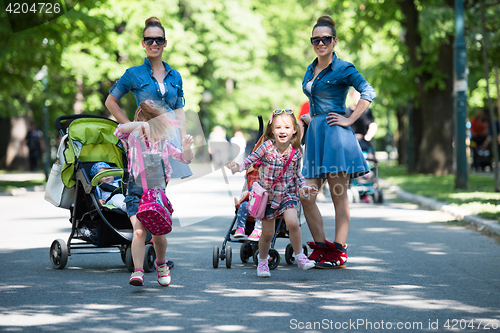 Image of twins mother with children  in city park