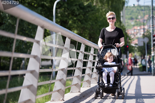 Image of mother pushed her baby daughter in a stroller