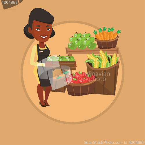 Image of Supermarket worker with box full of apples.