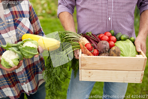 Image of senior couple with box of vegetables on farm