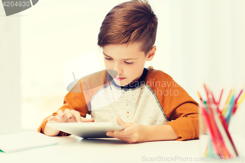 Image of close up of boy with tablet pc computer at home