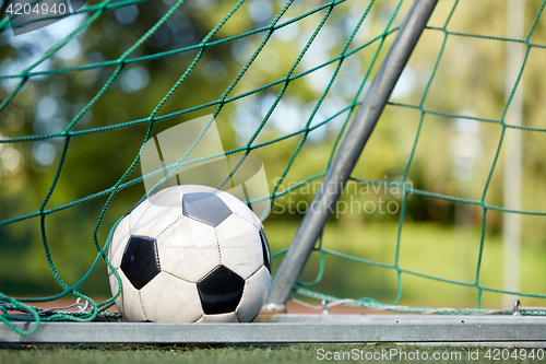 Image of soccer ball at goal net on football field