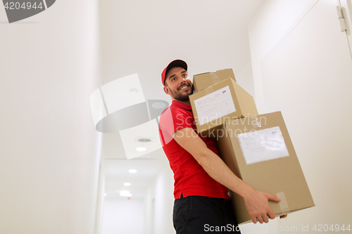 Image of delivery man with parcel boxes in corridor