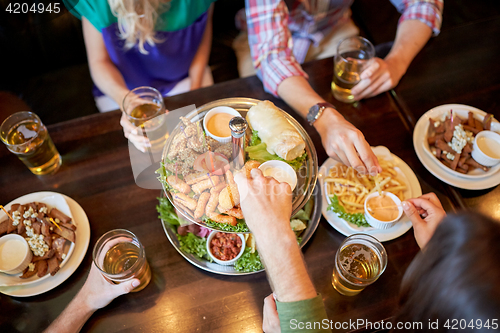 Image of friends eating and drinking at bar or pub