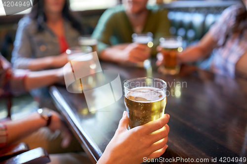 Image of friends drinking beer at bar or pub