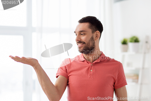 Image of happy man holding something imaginary at home