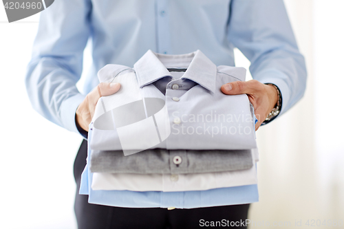 Image of close up of businessman holding shirts