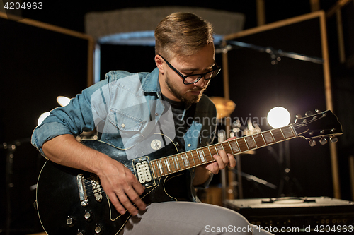 Image of man playing guitar at studio rehearsal