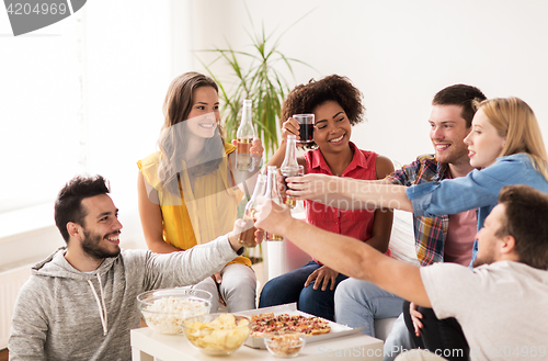 Image of friends having party and clinking drinks at home