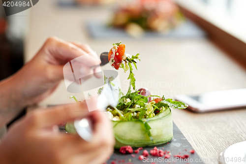 Image of woman eating cottage cheese salad at restaurant