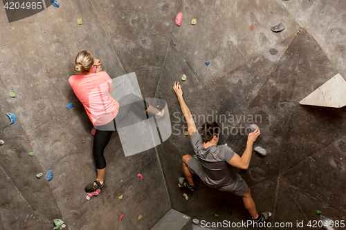 Image of man and woman exercising at indoor climbing gym