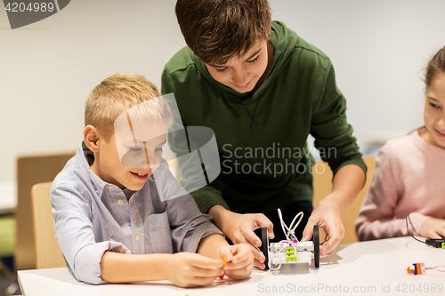 Image of happy children building robots at robotics school