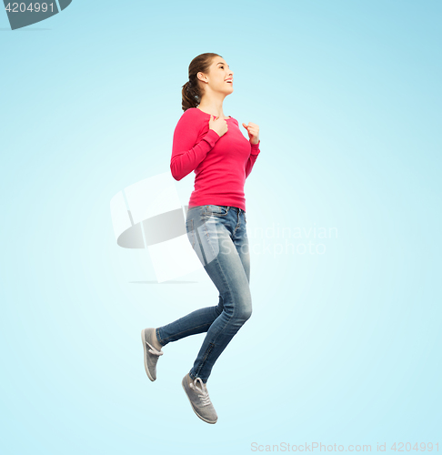 Image of smiling young woman jumping in air