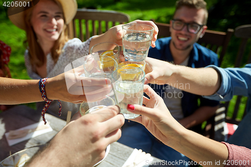 Image of happy friends with drinks at summer garden party