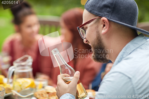 Image of happy man with beer friends at summer garden party